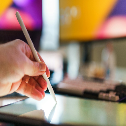 A person holding a pen for digital drawing